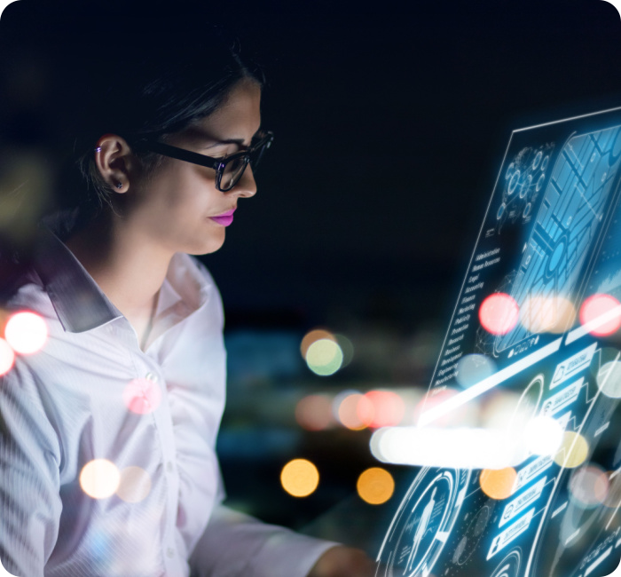 frau-laptop__700x650-02 Eine Frau mit Brille, die vor einem futuristischen grafischen Benutzerinterface sitzt